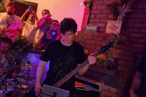 Baixista da banda Madressilva em destaque, tocando seu baixo com expressão e dedicação no palco. (reFestança, São Paulo) fotografia Bruno Arita'