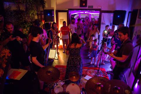 Vista por trás da banda Madressilva se apresentando no palco, com o público vibrante à frente, capturando a interação entre artistas e audiência. (reFestança, São Paulo) fotografia Bruno Arita'
