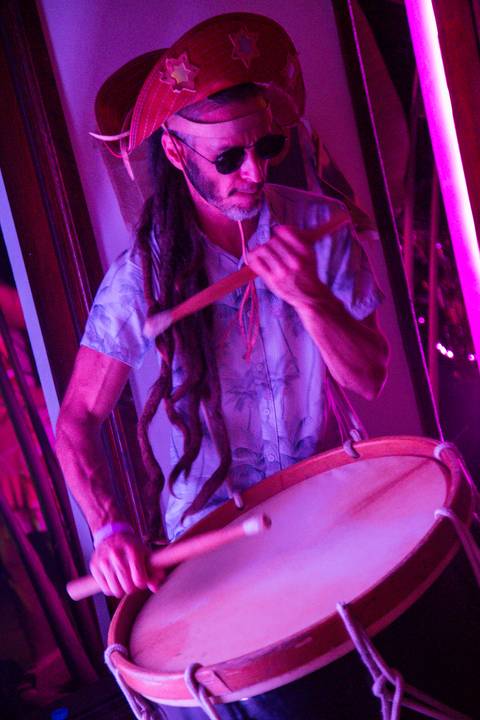 Músico da banda Ciência de Chico tocando um instrumento de percussão, vestindo trajes que remetem à cultura de Pernambuco, com foco na expressão e nos detalhes. (reFestança, São Paulo) fotografia Bruno Arita'