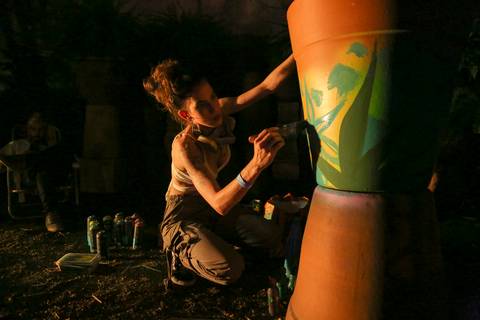 Close-up da mão da artista pintando detalhes em um vaso de barro durante a performance de living painting. (reFestança, São Paulo) fotografia Bruno Arita'