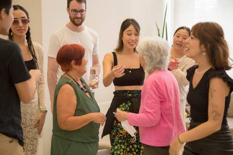 Aniversariante Reiko conversando com alegria e descontração em meio a familiares e convidados, desfrutando de sua festa de 74 anos.'