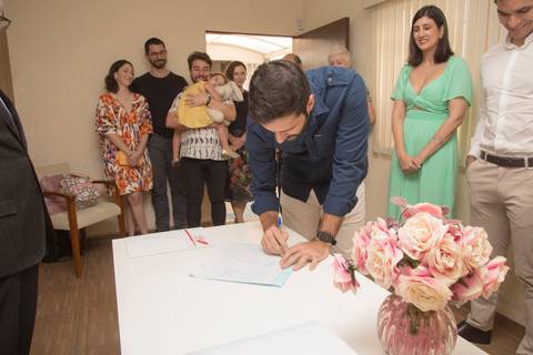 Padrinho assinando o documento oficial como testemunha no casamento civil de Ana e Leonardo no 28º Cartório Jardim Paulista'
