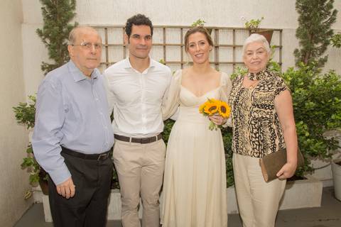 Casal Ana e Leonardo posando para foto com os pais da noiva, em um registro familiar após a cerimônia de casamento civil'