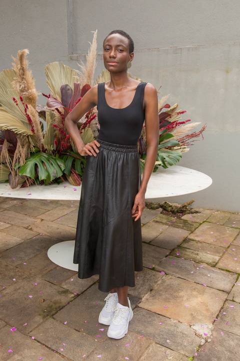 Convidada sorrindo e posando para foto na área externa do Instituto do Protagonismo Feminino, aproveitando o evento'