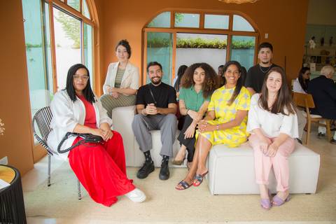 Alexandra Loras posando no sofá da sala decorada do Instituto do Protagonismo Feminino, ao lado de membros da equipe Westwing, celebrando a parceria'