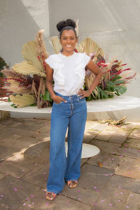 Convidada sorrindo e posando para foto na área externa do Instituto do Protagonismo Feminino, em um registro casual'