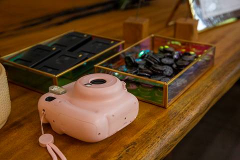 Plano detalhe de uma câmera instantânea e imãs de geladeira personalizados, oferecidos como recordação do evento da Casa Riachuelo na CASACOR São Paulo 2025. (Evento Casa Riachuelo CASACOR 2025, São Paulo, Fotos Bruno Arita)'