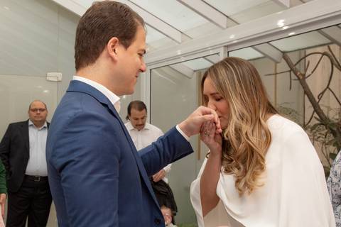 Noiva beijando a aliança que acabou de colocar no dedo do noivo, em um momento de afeto. (Casamento Civil, São Paulo, Fotógrafo Bruno Arita)'