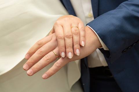 Plano detalhe das mãos dos noivos, com as alianças de recém-casados em evidência. (Casamento Civil, São Paulo, Fotógrafo Bruno Arita)'