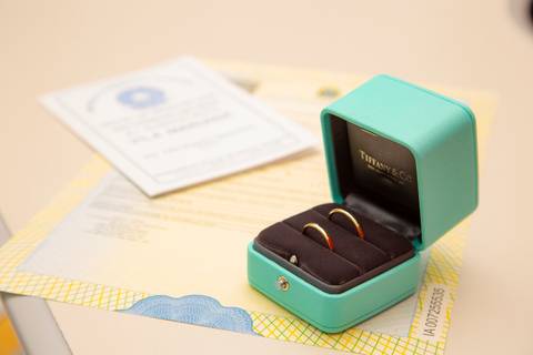 Foto clássica das alianças da Tiffany & Co. em cima da certidão de casamento, simbolizando a união dos noivos. (Casamento Civil, São Paulo, Fotógrafo Bruno Arita)'