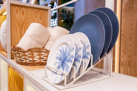 Pratos e sousplats da nova coleção 'Memórias de Verão', exibindo o design e a cor dos produtos da Casa Riachuelo, com toalhas ao fundo. (Lançamento Casa Riachuelo, Rua Oscar Freire, São Paulo, Fotos Bruno Arita)'