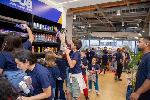 Crianças organizando os produtos nas prateleiras do mini mercado na Plurix, como parte da brincadeira de 'ser mercadinho'. (Evento Plurix, São Paulo, Fotógrafo Bruno Arita)'