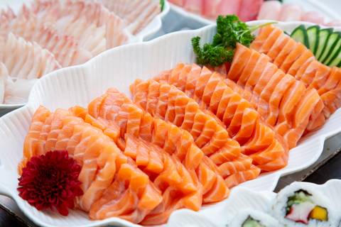 Plano detalhe de sashimi fresco de salmão servido no buffet de comida japonesa do Restaurante Nanako. (Aniversário em Dobro, Nanako, São Paulo, Fotógrafo Bruno Arita)'