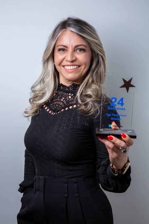 Retrato de Mulher com fundo branco, segurando uma premiação que ganhou, em pose clássica. (Retrato Corporativo, São Paulo, Fotógrafo Bruno Arita)'