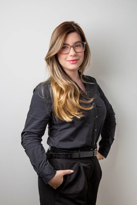 Retrato de Mulher em roupa preta, em fundo branco, com pose parcialmente de lado e olhar direto para a câmera. (Retrato Corporativo, São Paulo, Fotógrafo Bruno Arita)'