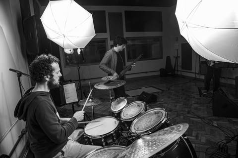 Foto de making of (preto e branco) do baterista Bruno Pigat, com os modificadores de luz visíveis, mas posicionado à esquerda na foto. (Banda Madressilva, Ensaio Musical, Fotos Bruno Arita)'