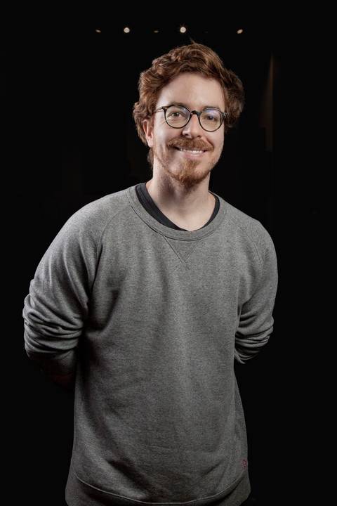 Retrato do guitarrista Ivan Lucchini, posando de braços para trás e usando óculos, em postura amigável. (Banda Madressilva, Ensaio Musical, Fotos Bruno Arita)'