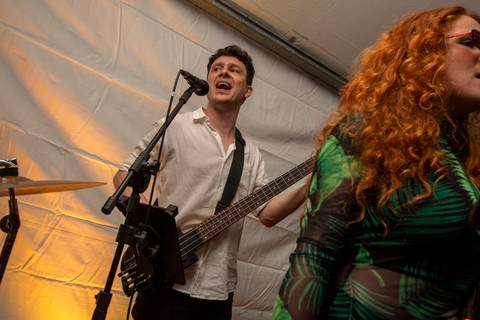 Baixista Marco Augusto, da Banda Madressilva, fazendo backing vocal e tocando seu instrumento com foco. (Ninfa Flores, São Paulo, Fotos Bruno Arita)'