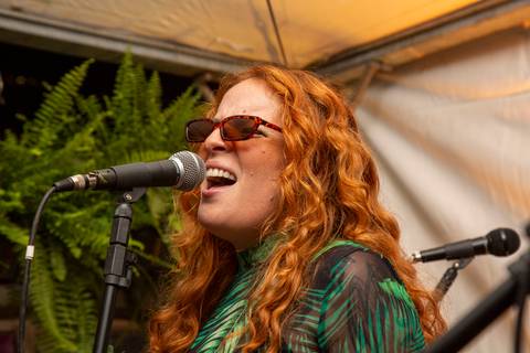 Vocalista Agnes Gomes, da Banda Madressilva, em destaque, cantando com expressão de intérprete. (Ninfa Flores, São Paulo, Fotos Bruno Arita)'
