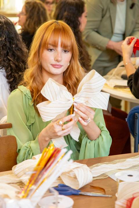 Influencer Luiza Panucci (@luizapanucci) focada, fazendo seu laço branco com detalhes dourados. (Westwing Moema, São Paulo, Fotos Bruno Arita)'
