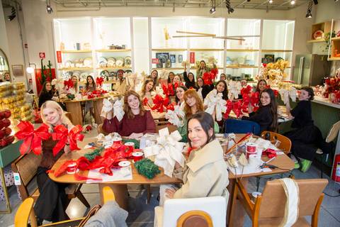 Plano aberto mostrando todos os participantes nas mesas, exibindo a fase do laço pronta em seus projetos de decoração natalina. (Westwing Moema, São Paulo, Fotos Bruno Arita)'