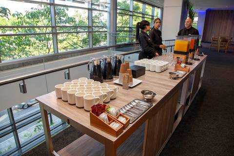 Mesa de café do Coffee Break com sucos, xícaras e água, organizada para os participantes. (Grand Hyatt SP, Evento Corporativo, Fotos Bruno Arita)'