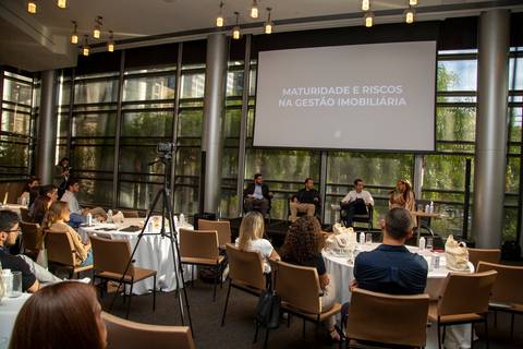 Plano aberto mostrando a plateia e o palco ao fundo com os participantes do debate. (Grand Hyatt SP, Evento Corporativo, Fotos Bruno Arita)'