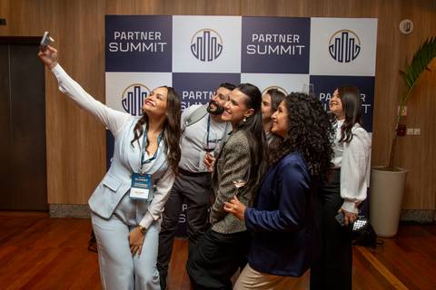 Membros da Partner PSE fazendo uma selfie em grupo em frente ao backdrop do evento. (Grand Hyatt SP, Evento Corporativo, Fotos Bruno Arita)'