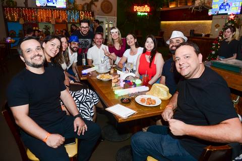 Grupo de participantes posando para foto na mesa durante a Confraternização de Fim de Ano da Plurix. (Boteco Parō!, São Paulo, Fotos Bruno Arita)'