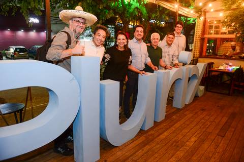 Participantes posando para foto em grupo no letreiro de madeira da Plurix. (Confraternização Plurix, Boteco Parō!, Fotos Bruno Arita)'