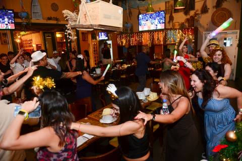 Participantes formando um trenzinho e percorrendo o Boteco Parō! em momento de alta descontração. (Confraternização Plurix, Evento Corporativo, Fotos Bruno Arita)'