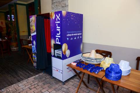 Cabine de fotos com cortina e identidade visual da Plurix, com chapéus e acessórios para as fotos divertidas. (Confraternização Plurix, São Paulo, Fotos Bruno Arita)'