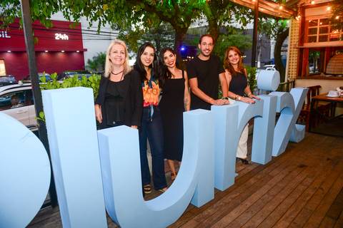 Grupo de participantes posando e sorrindo atrás do letreiro da Plurix, celebrando o sucesso do ano. (Confraternização Plurix, São Paulo, Fotos Bruno Arita)'