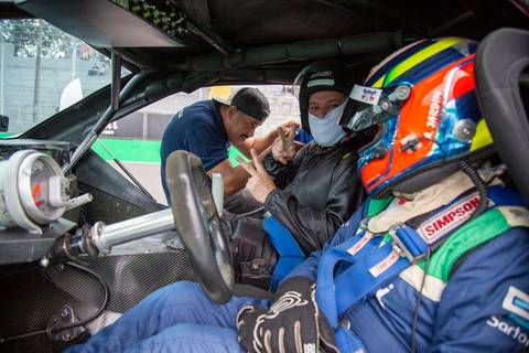 Participante dentro do carro de corrida, feliz e fazendo sinal de 'V' após a volta rápida. (L8 Group, Ruckus Networks, Fotos Bruno Arita)'