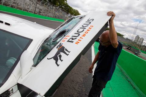 Pessoa da equipe segurando a porta do carro, com destaque para o logo Ruckus Networks. (Stock Car, Interlagos, Fotos Bruno Arita)