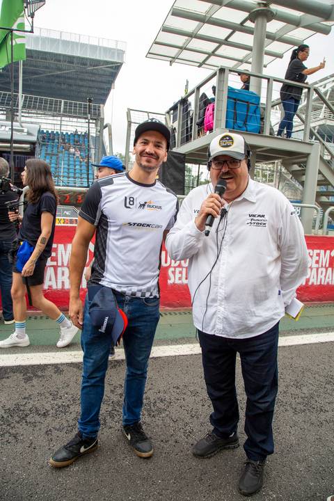 Participante posando para foto com o locutor Francisco Antônio Marques nos boxes. (Stock Car, Interlagos, Fotos Bruno Arita)'