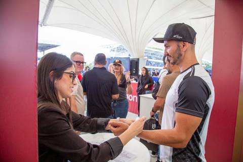 Recepcionista do Camarote Snapdragon colocando a pulseira de acesso em um participante da L8 e Ruckus. (Stock Car, Interlagos, Fotos Bruno Arita)'