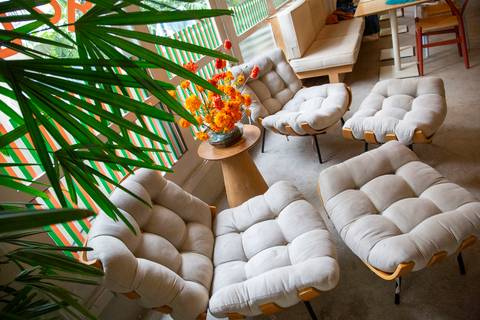 Duas poltronas sofisticadas com suporte para os pés na área interna do bar no Edifício Renata. (Westwing Collection, Fotos Bruno Arita)'