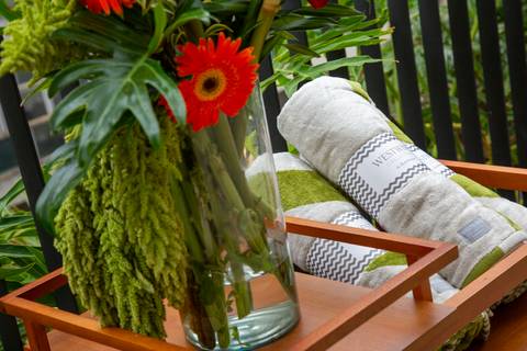 Composição fotográfica com flores em primeiro plano e toalhas da coleção Westwing ao fundo. (P.arador, São Paulo, Fotos Bruno Arita)'