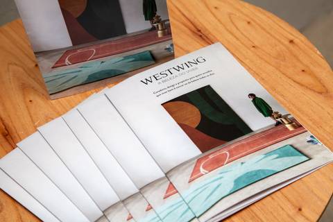 Plano detalhe de material gráfico da Westwing com a frase 'A beleza do viver' em mesa de recepção. (P.arador, Edifício Renata, São Paulo, Fotos Bruno Arita)'