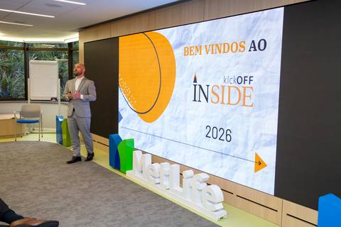Foto de Alex Karam, líder da Agência Inside, em momento de fala expressivo durante o evento na MetLife SP. Ele veste terno cinza claro e apresenta as metas para 2026. (Liderança, Fotos Bruno Arita)'