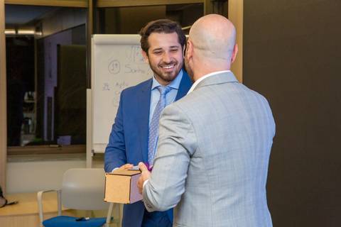 Participante recebendo caixa de vinho como premiação das mãos de Alex Karam no palco. (Reconhecimento Inside, Fotos Bruno Arita)'