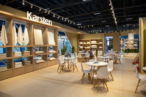 Plano aberto da área de atendimento vazia com móveis brancos e logotipo da Karsten em destaque na estante. (ABUP Show 2026, Fotos Bruno Arita)'