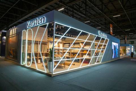 Visão panorâmica do estande da Karsten no Distrito Anhembi, mostrando a estrutura de ponta a ponta com o logotipo iluminado e um 'K' gigante vazado em destaque na lateral esquerda. (Arquitetura Promocional, ABUP Show 2026, Fotos Bruno Arita)'