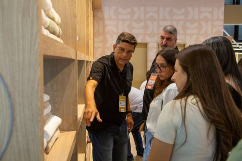 Vendedor da Karsten apresentando toalhas e detalhes técnicos para grupo de clientes interessados. (Fotos Bruno Arita)'