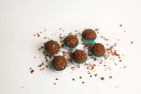 Seis brigadeiros com granulado de doce de leite organizados em bandeja para exposição em feiras e eventos. Registro por Bruno Arita.'