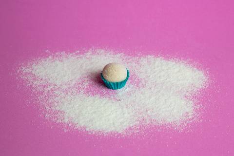 Close-up de um brigadeiro de Leite Ninho, focando na textura aveludada e finalização impecável. Registro por Bruno Arita.'