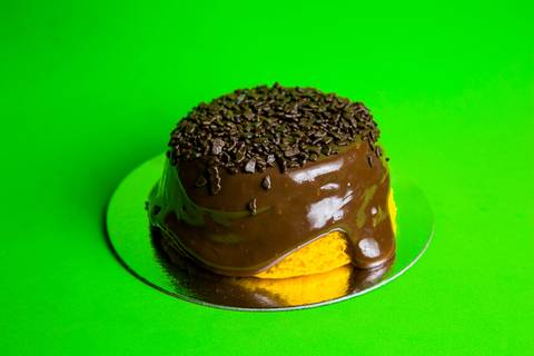 Foto de um Mini Bolo Vulcão de Cenoura da Bem Caseirinho SP, Morumbi, com cobertura cremosa transbordando. A imagem foca na textura e no apelo visual caseiro para e-commerce e iFood.'