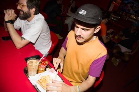 Visão em ângulo plongee de mesa com suco e comida durante evento no Sina Café. Foto por Bruno Arita.'