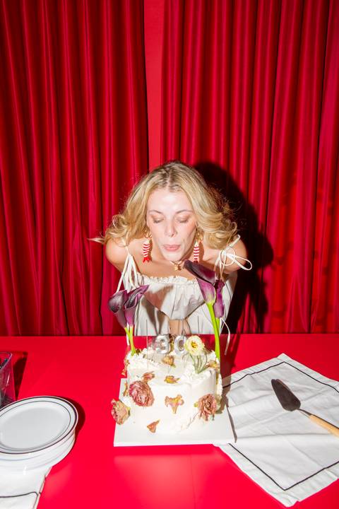 Erika assoprando as velas de 30 anos em foto vibrante com luz de flash direto. Autoria: Bruno Arita.'